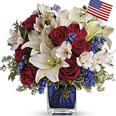 <p>A patriotic pick to send a brave veteran, decorate your Fourth of July picnic, or celebrate Memorial Day. Lush red, white and blue flowers are presented in a deep blue glass cube vase along with an American flag.<br />
Red roses, white asiatic lilies, white alstroemeria, blue statice and red carnations are gathered with green pitta negra, seeded eucalyptus and a small American flag in a cobalt blue glass cube.</p>