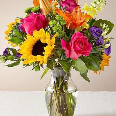 <p>The Best Day™ Bouquet is ready to create a moment your recipient will always remember! An instant mood booster with it's mix of bright bold colors, this gorgeous fresh flower arrangement brings together sunflowers, hot pink roses, purple double lisianthus, orange LA Hybrid Lilies, yellow snapdragons, green button poms, and lush greens to make this day, their best day. Presented in a clear glass vase, this fresh flower arrangement is made just for you to help you send your warmest birthday, congratulations, or get well wishes to your favorite friends and family.</p>